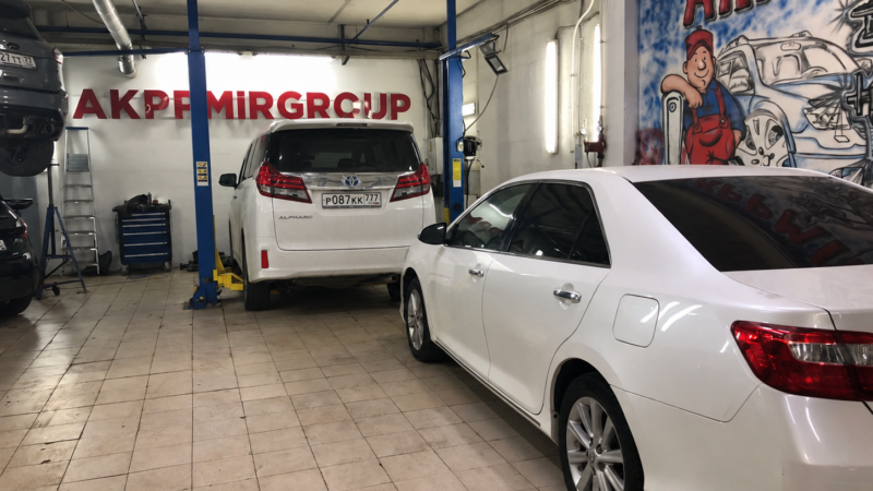 Белый Toyota Alphard в зоне подъёмника автосервиса АКППМИРGROUP